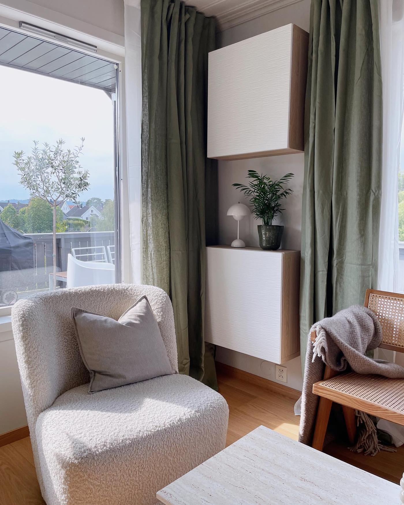 Een woonkamer met twee BESTÅ meubels die boven elkaar hangen.