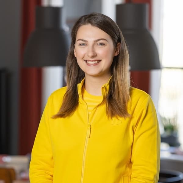 Eimantė Nemanė, Head of IKEA Interior design department is smiling with a yellow IKEA uniform
