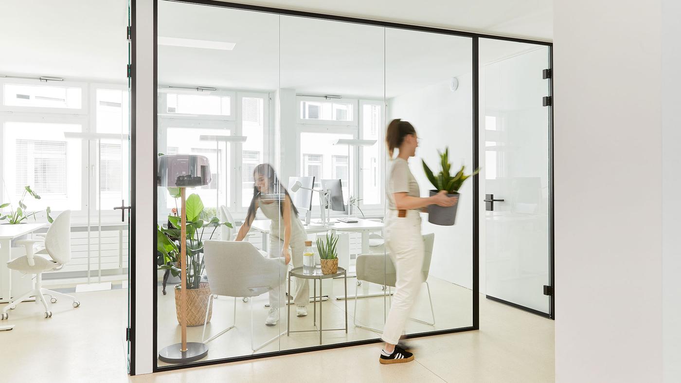 Ein Büroarbeitsplatz mit Schreibtisch, Büroshtuhl mit hoher Lehne und einem Büroregal mit Ablagemöglichkeiten für Dokumente