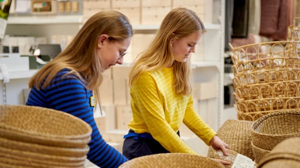 Ein IKEA Lehrling zur Einzelhandelskauffrau steht in der Lampenabteilung und lächelt