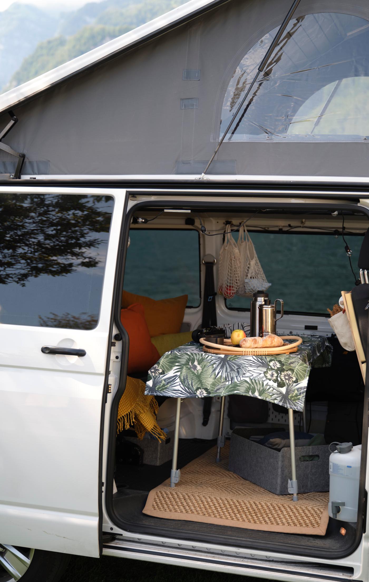 Ein Lieferwagen mit offener Tür und einem Picknicktisch darin.