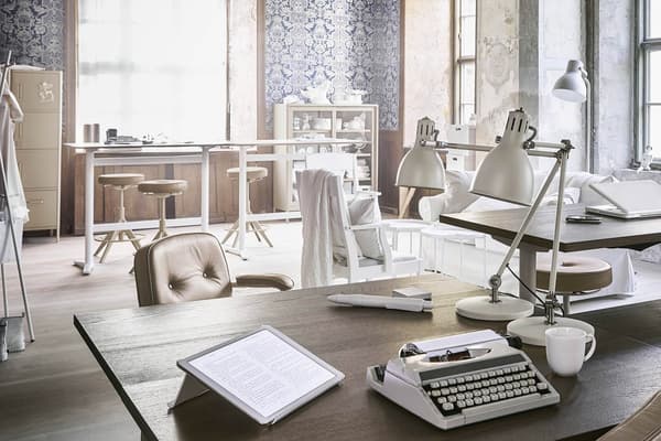 Ein offenes Büro in einem Loft mit hellen Büromöbeln im Industriestil