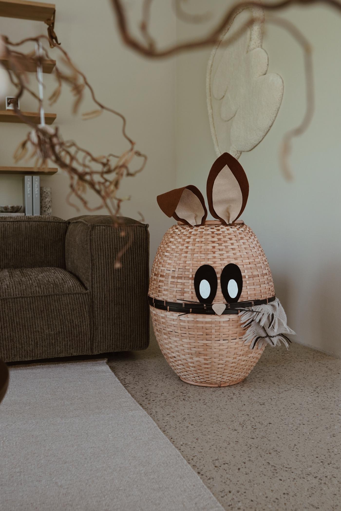 Ein Osterhasenkorb in der Ecke neben der Couch.