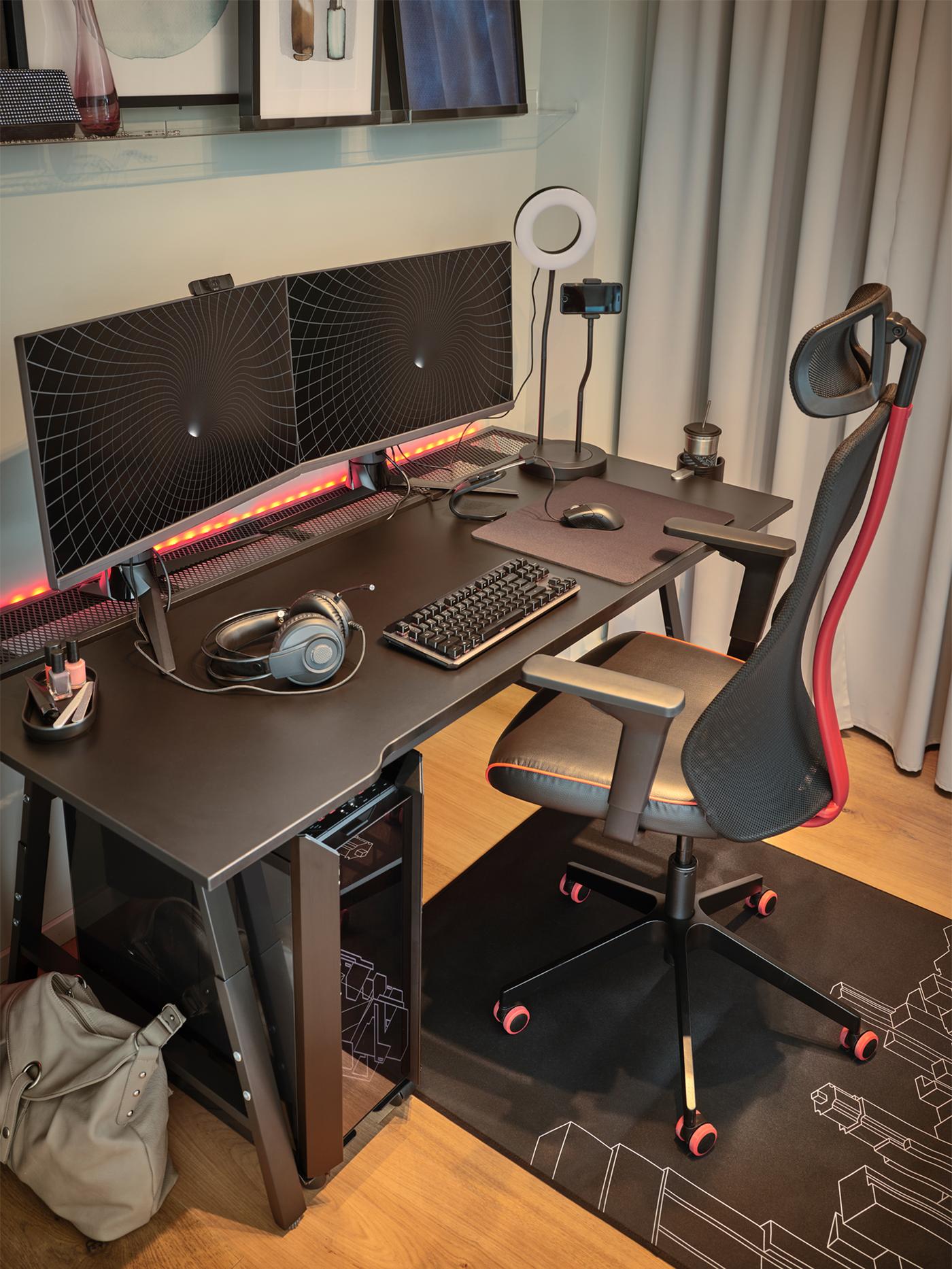 Ein schwarzer MATCHSPEL Gamingstuhl, ein UTESPELARE Gamingschreibtisch und graue Gardinen bestimmen diesen Gamingbereich.