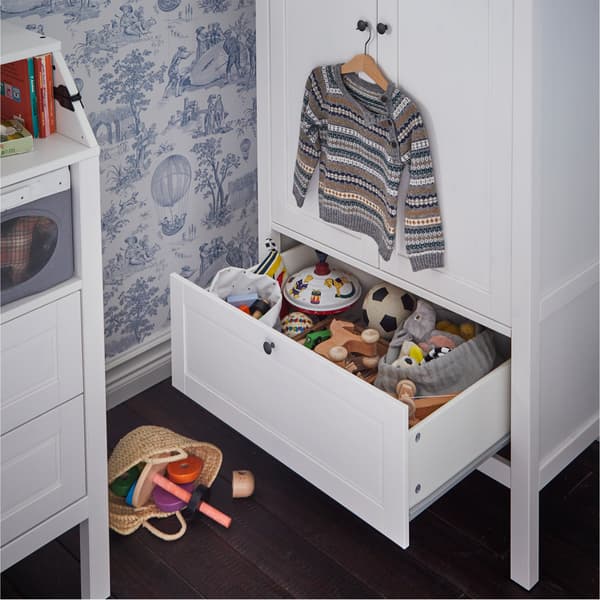 Ein SUNDVIK Kleiderschrank in Weiß mit geöffneter Schublade. Darin ist Stoffspielzeug zu sehen.