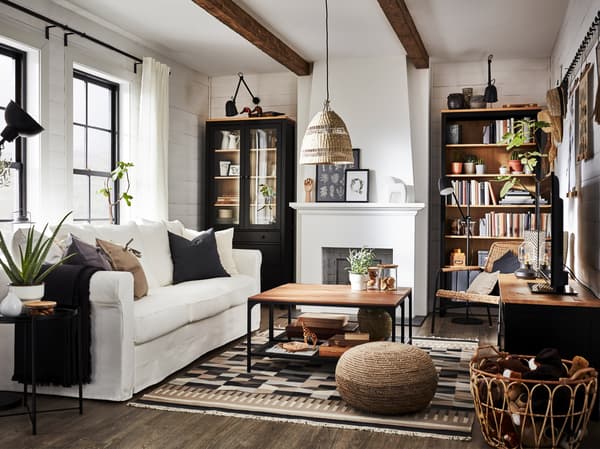 Ein traditionelles Wohnzimmer mit einem Bücherregal, einer Vitrine, einer TV-Bank aus Kiefernholz, einem weißen Sofa, einem Rattan-Sessel und einem Tabletttisch.