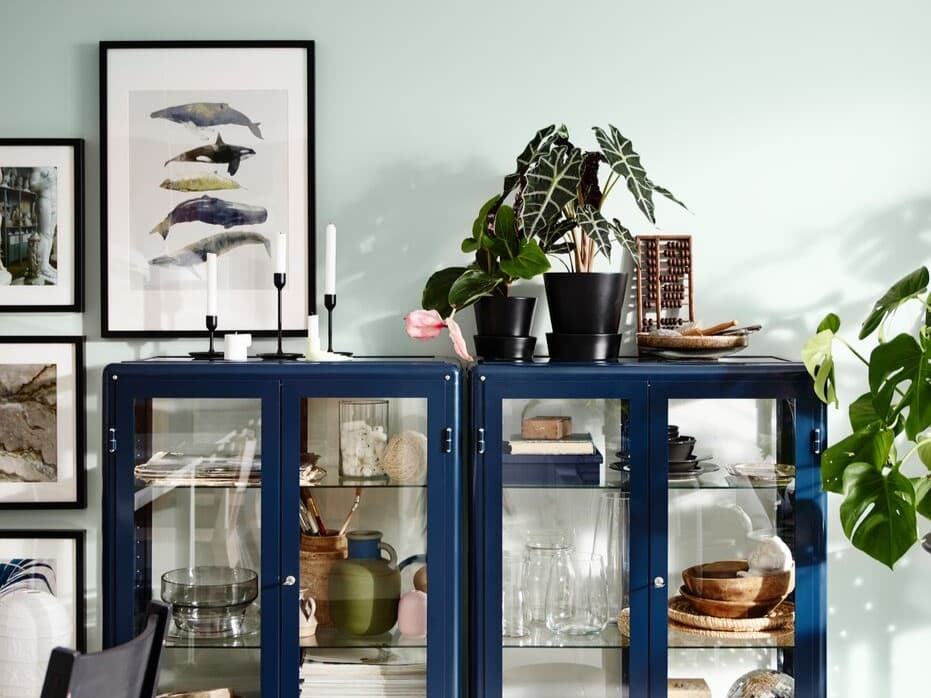 Eine FABRIKÖR Vitrine in Blau hübsch dekoriert in einem Wohnzimmer.