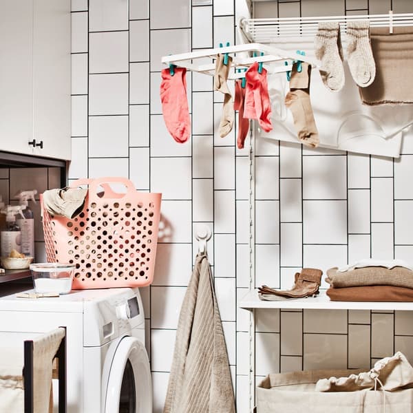 Eine im Badezimmer eingerichtete Waschküche mit Waschmaschine, Aufbewahrung für Wäsche mit Schrank und einer Wäschekombination mit Boden.