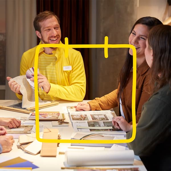Eine kleine Gruppe sitzt an einem Tisch bei einem Workshop.