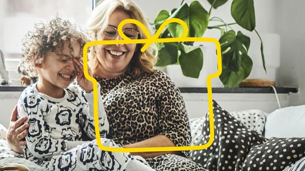Eine Mutter und ihr Kleinkind sitzen auf dem Sofa.