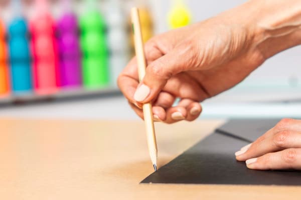 Eine Person zieht eine Linie nach mit einem Stift.