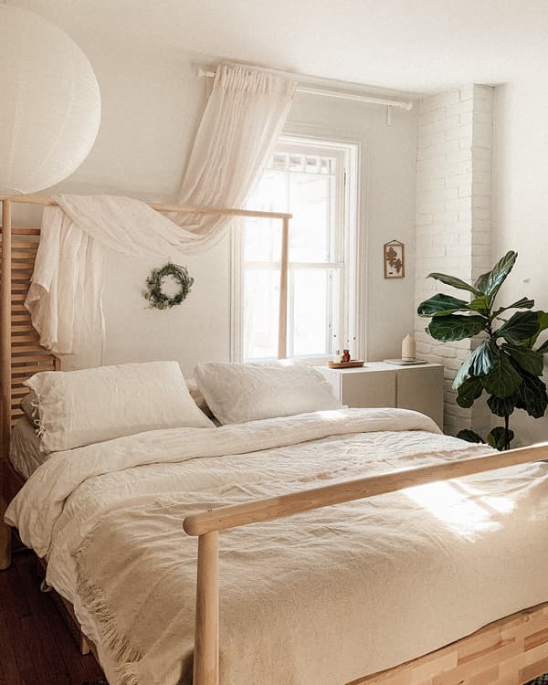 Emilie's bedroom with sunlight filtering through the window, featuring the GJÖRA birch bed, dressed with neutral bedlinens.