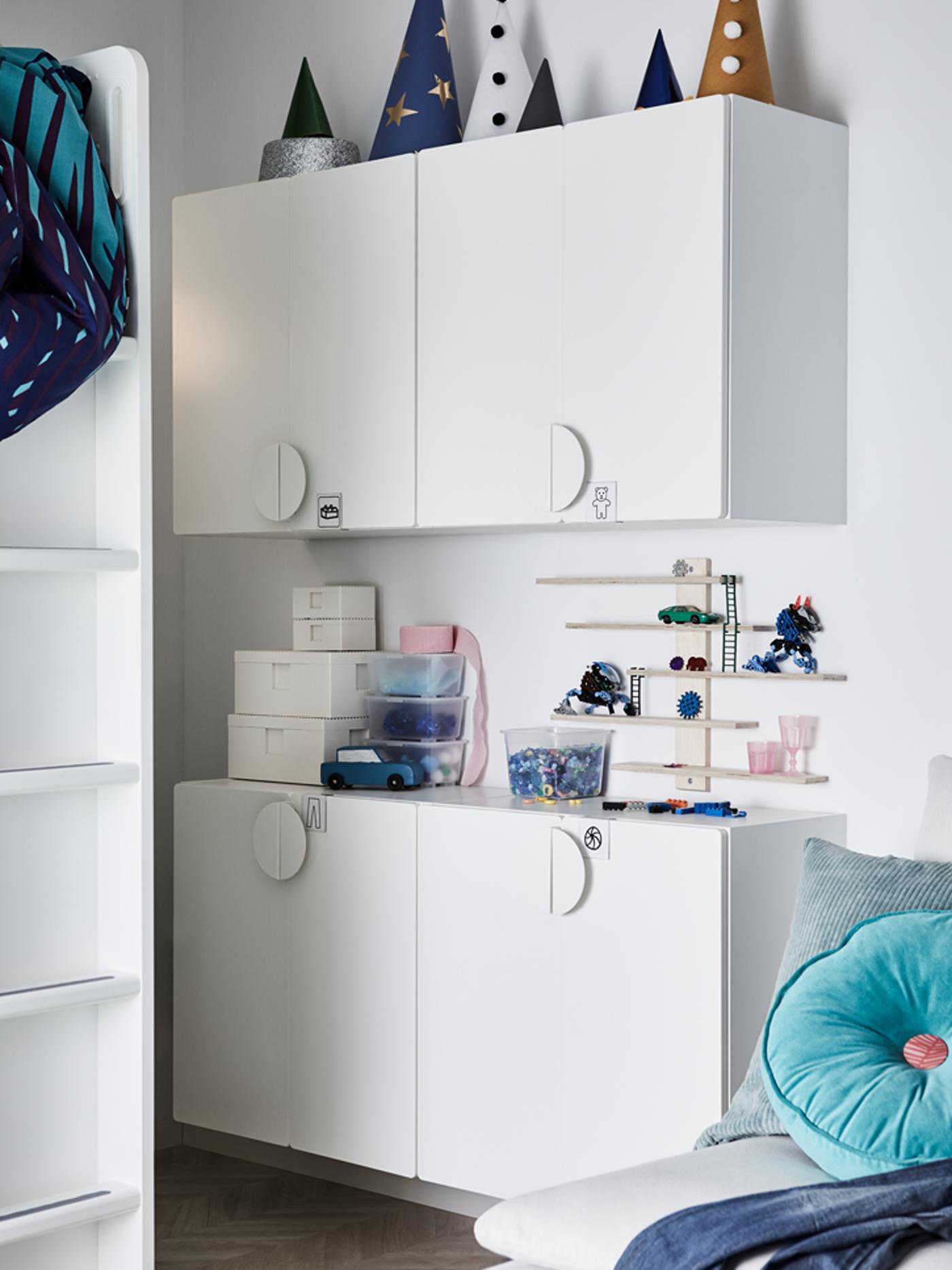 Empat kabinet dinding SMÅSTAD berwarna putih dengan pelbagai kotak dan item-item lain terletak di atasnya, dan tangga katil loteng.