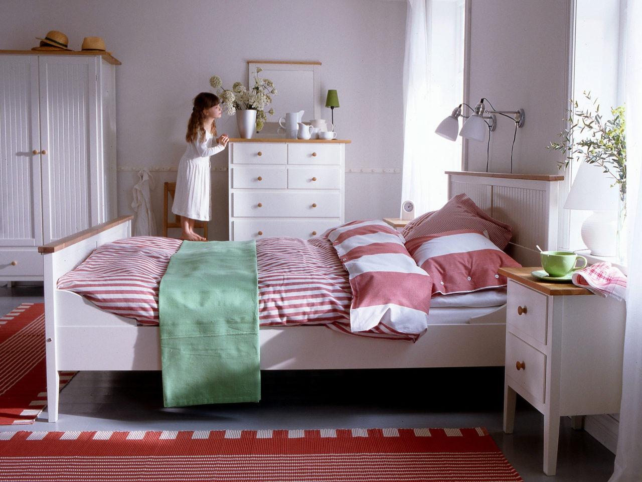 En bild från 1990-talet på en liten flicka i hennes sovrum som kollar ut ur fönstret. Rummet är möblerat av IKEA.