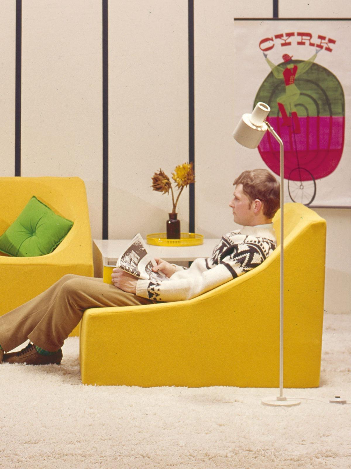 En bild från IKEAs katalog under 1960-talet, där en man sitter i en gul retro fåtölj.