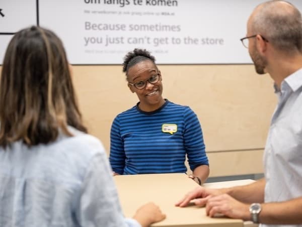 En IKEA medarbetare på varuhuset som hjälper kunder med en retur.