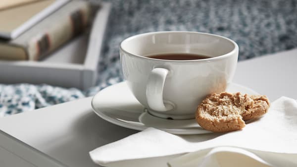 En kaffekopp och en kaka bredvid en vit servett.