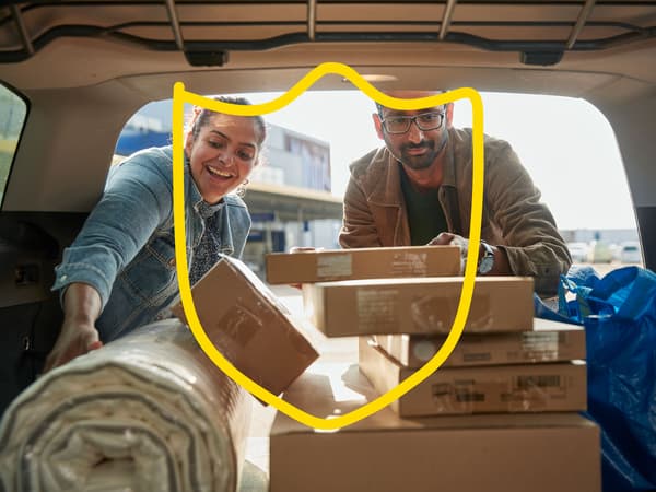 En man och en kvinna packar produkter i bilen.


