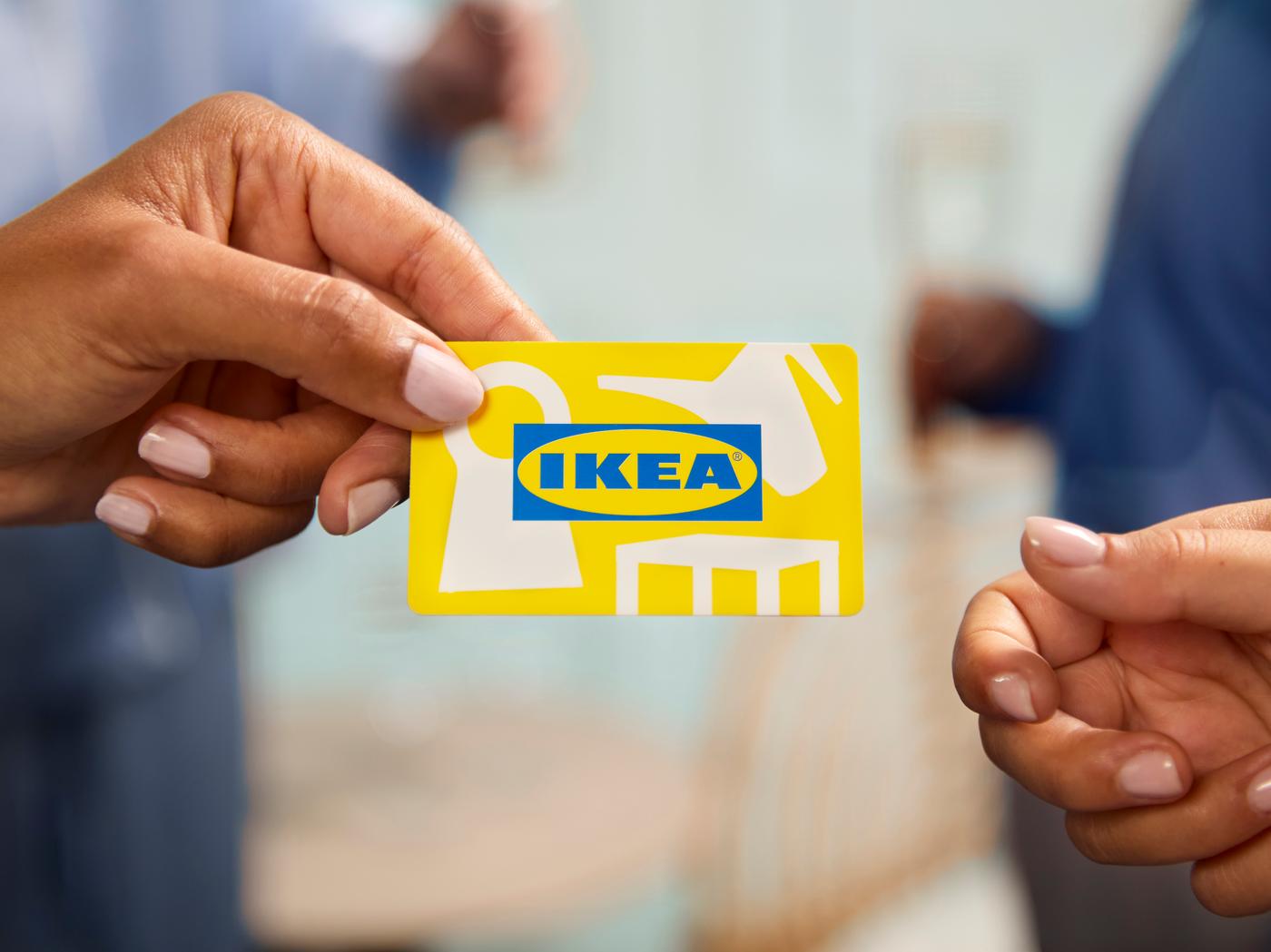 En person ger en annan ett IKEA presentkort.
