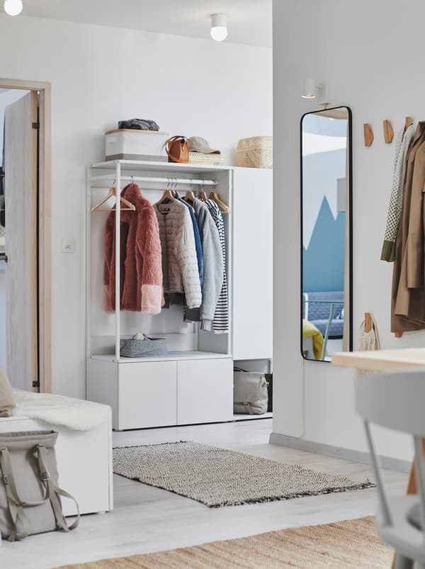 Entrée avec stations ouvertes pour suspendre ou ranger des vêtements, dont une garde-robe PLATSA blanche.