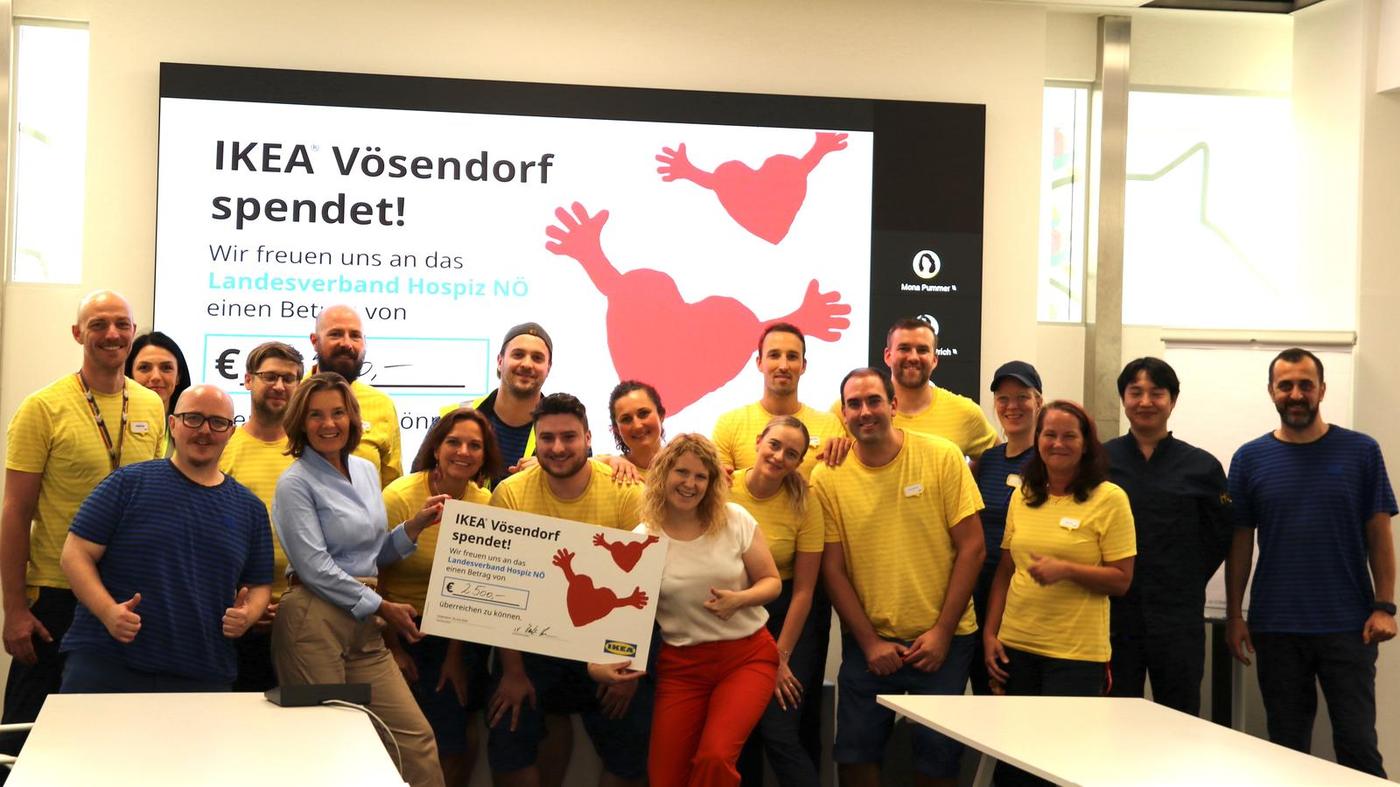 Es ist ein Bild von IKEA Vösendorf Mitarbeitern zu sehen, die ein Plakat eines Spendenbeitrags in der Hand halten. 