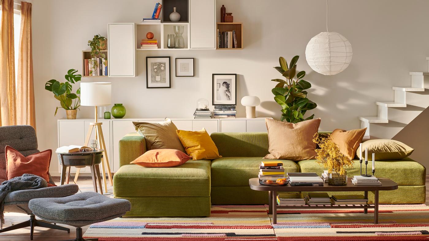 Es ist ein helles Wohnzimmer mit einem JÄTTEBO 3,5er Sofa mit Récamiere und verschiedenen EKET Wandschränken zu sehen.