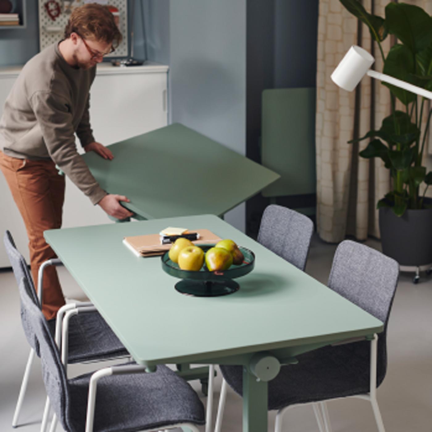 Es ist ein sonniges Büro mit verschiedenen Arbeitsplätzen und vielen Grünpflanzen, viel Deko und Wandkunst zu sehen.