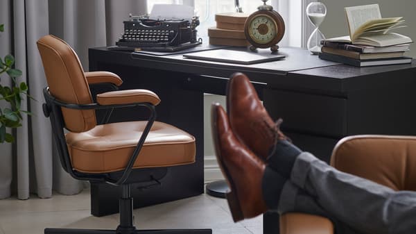 Escritorio y pies de una persona apoyados en primer plano