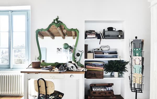 Espace créatif avec bureau, murs blancs et miroir vert.