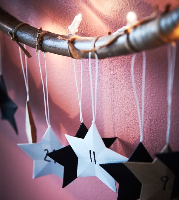 Étoiles en papier accrochées à un hula hoop décoré.