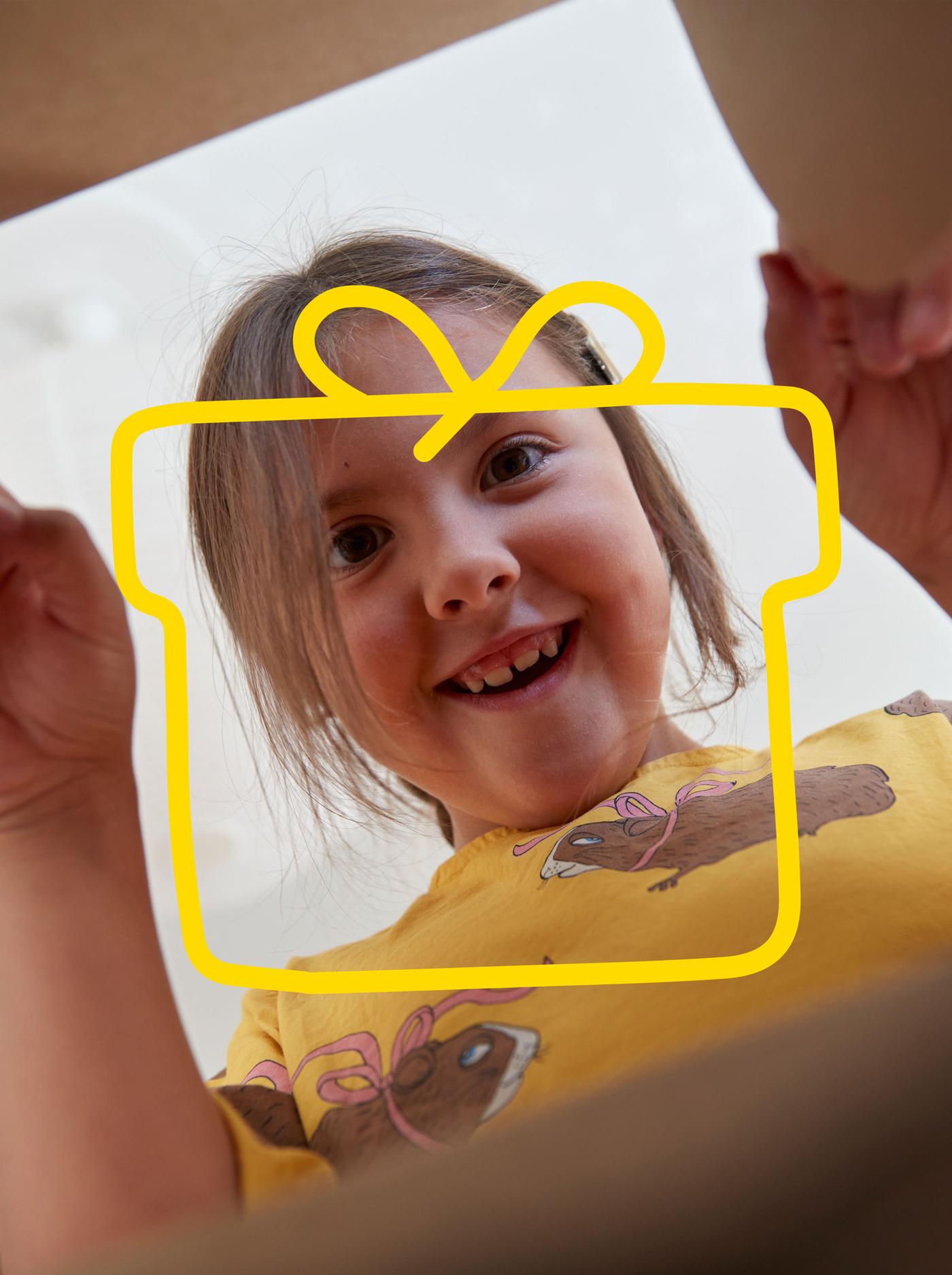 Ett barn ler och kollar in i en paffkartong
