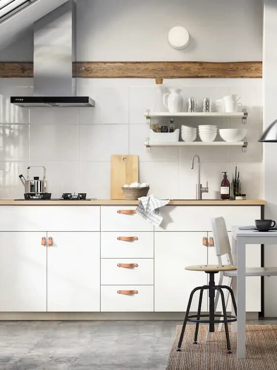 Ett vitt IKEA kök med detaljer i trä.