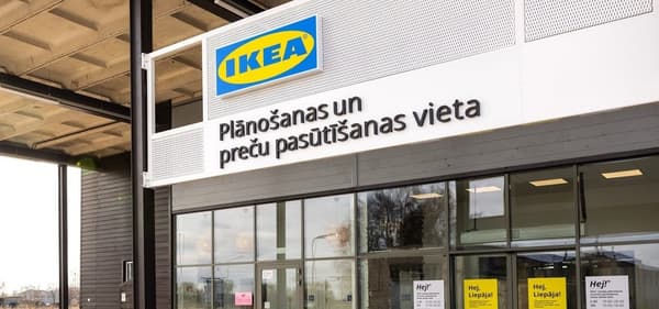 Exterior of an IKEA planning and ordering point in Latvia, with the sign 'Plānošanas un preču pasūtīšanas vieta' above the entrance.