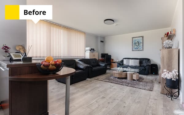 Family living room with black leather seating, a coffee table, a bar table and vertical blinds covering the large window. Text in the top-left corner reads: “Before”.						