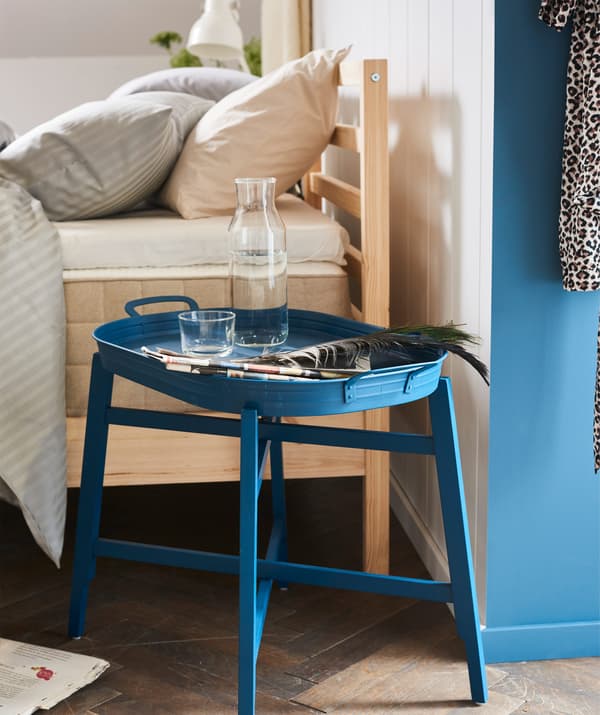 Fancy eating breakfast in bed? Use a smart tray table as a bedside table! Try IKEA FRIDAFORS blue tray table.