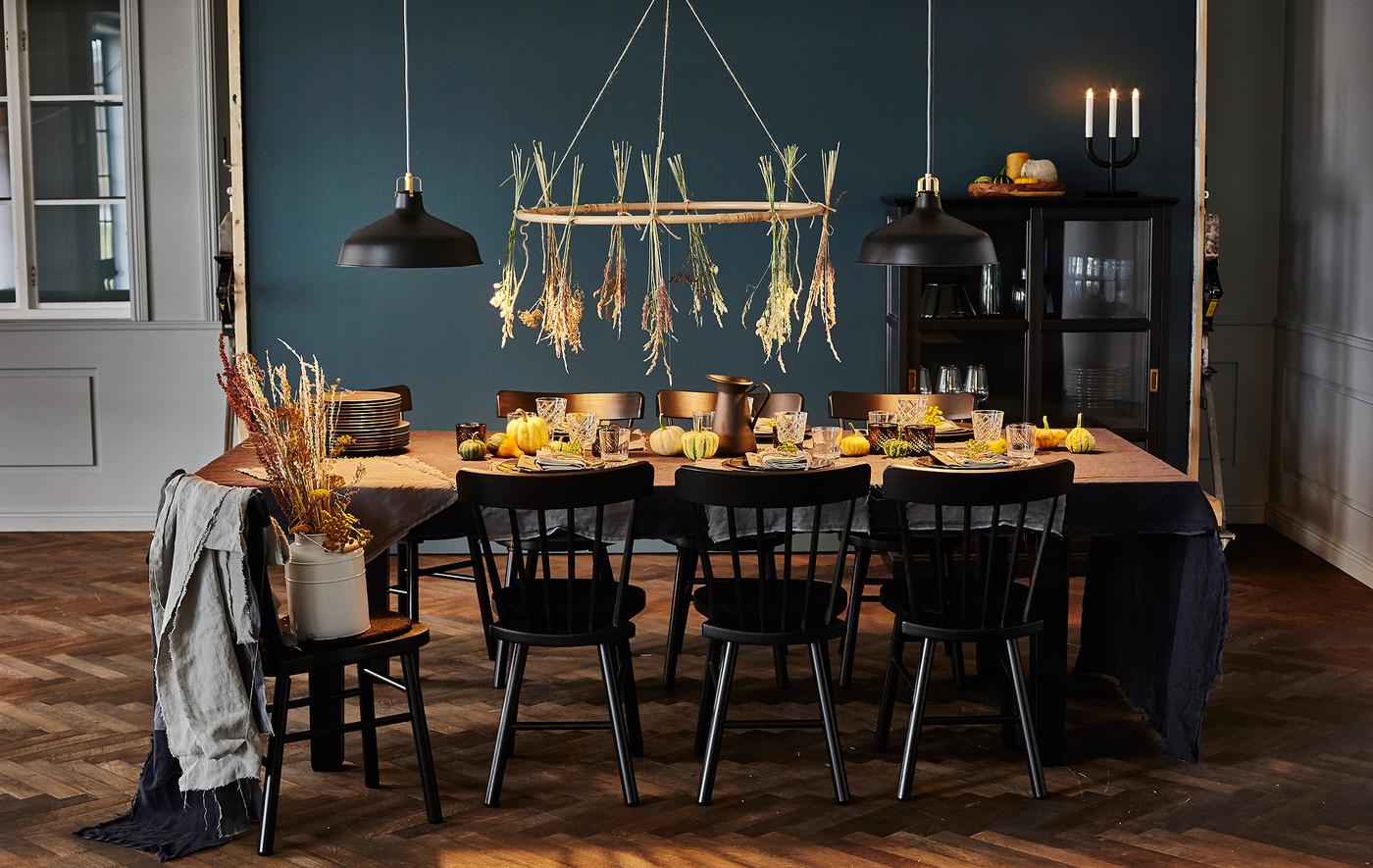 Femme en train de poser des assiettes sur une table décorée sur le thème des bienfaits de l'automne.