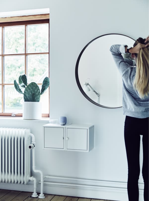 Fille en train de se coiffer devant le miroir.