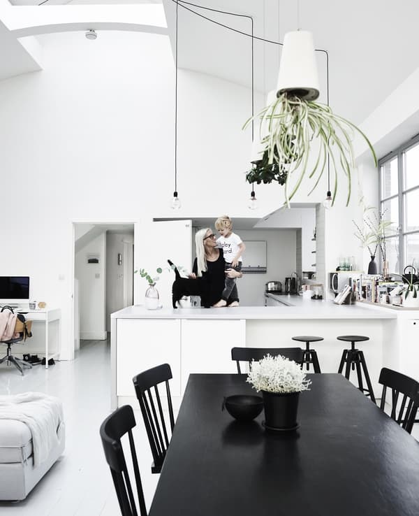 Fiona and her son, Stanley, in their all-white open plan kitchen area, including a vintage black dining table.