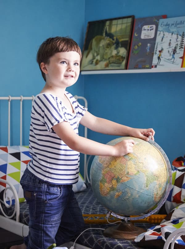 Five-year-old Viggo plays with a globe in his colourful bedroom.