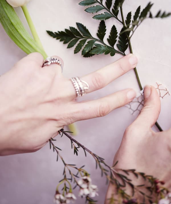 Fixing a flower stem to a white wall with monochrome patterned washi tape.