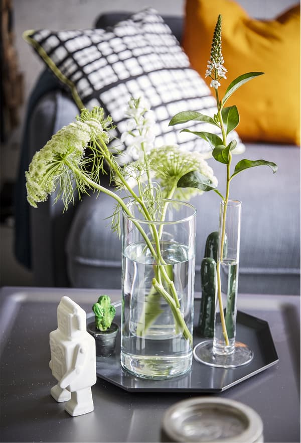 Fleurs coupées dans des vases, sur un plateau.