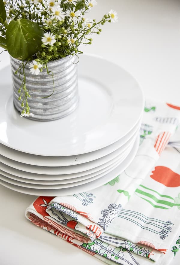 Fleurs présentées sur une pile d’assiettes.