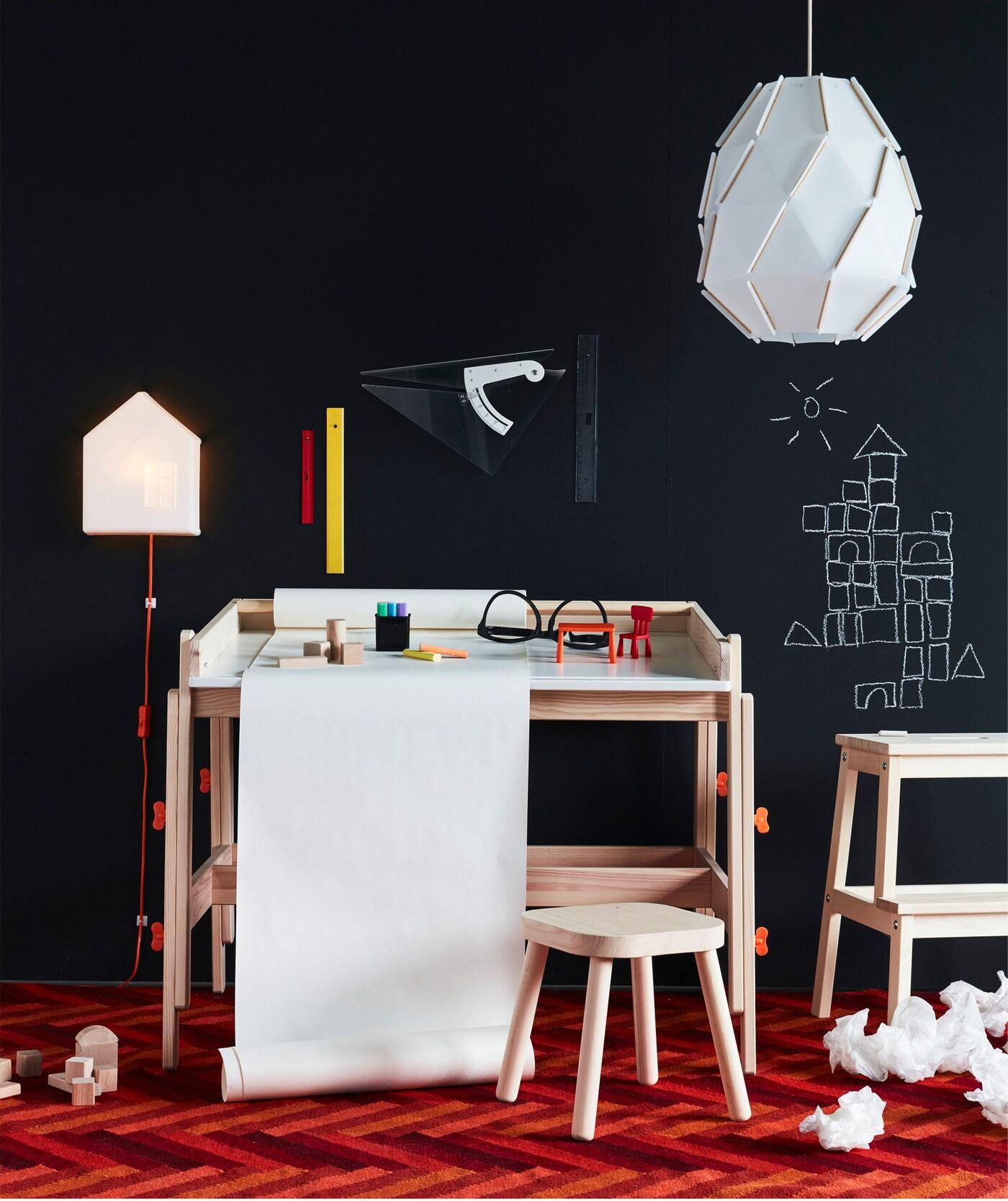 FLISAT Schreibtisch mit Papierrolle und Mal- und Spielsachen und jede Menge Platz für Kreativität in kontrastreichem Raum.