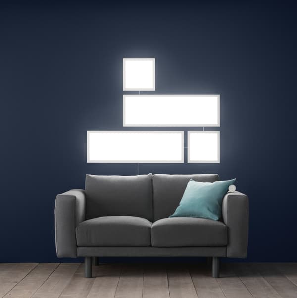 FLOALT LED-LICHTPANEELE vor einem grauem Sofa