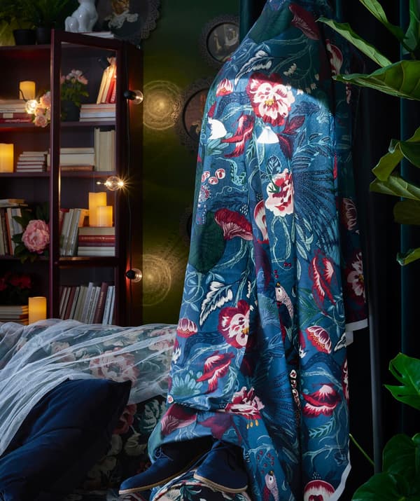 Floral fabric has been draped over a floor lamp to create a ghost-like effect.