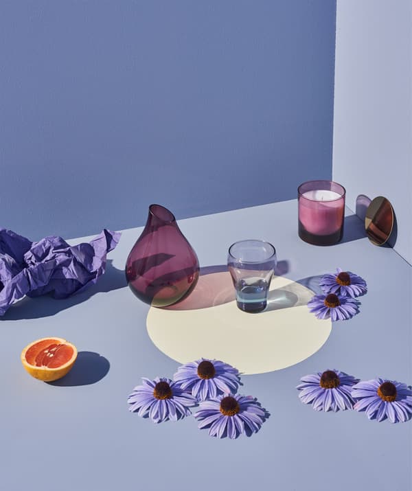 Flowers and fruit artfully frame a lilac TÖRSTIG glass.