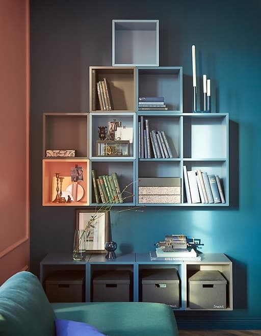 For living room furniture with impact, cover a wall in EKET cabinets from IKEA. Attach them together and in rows to make a unified square. Different shades of blue and grey create a custom style and accent your books, mementoes and other treasures.