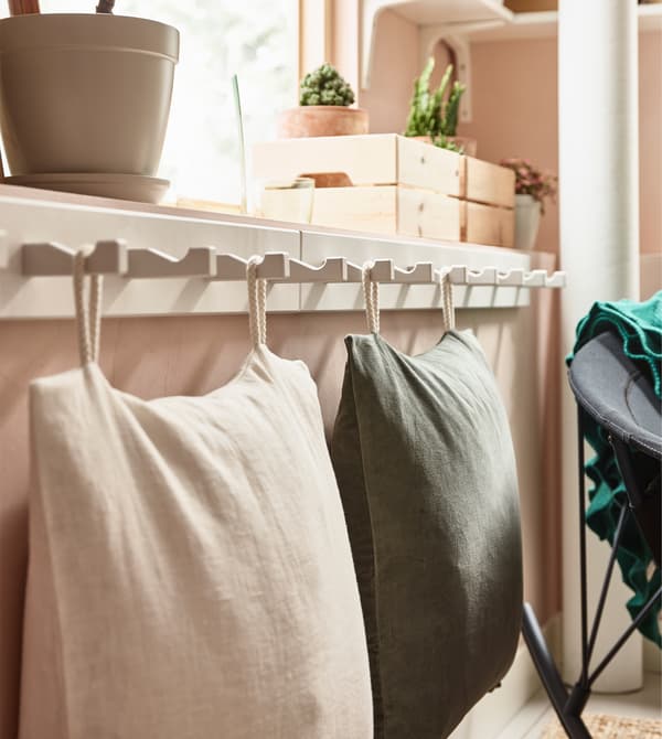 For low seating in a living room, consider using soft, comfy cushions. IKEA has lots of colours, sizes and materials to choose from. You can even save space by sewing fabric loops on them and hanging them on a rack with hooks like this white KUBBIS.