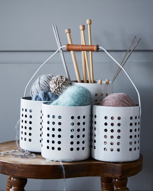 Four IKEA ORDNING utensil holders are grouped together to hold knitting supplies.