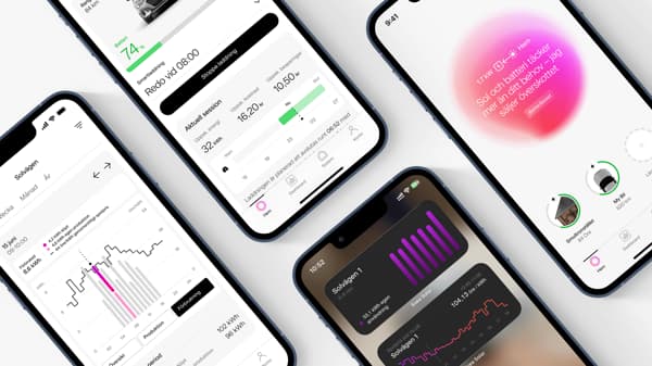 Four smartphones are lying on a white surface, displaying different screens from a health or fitness app. The screens show graphs, statistics and colored bars in pink, black and green, with information about heart rate, activity and metrics.